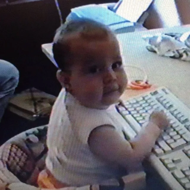Michael as a baby, typing on a computer keyboard.